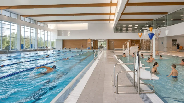 Des nageurs et des familles profitent des bassins d’une piscine municipale.